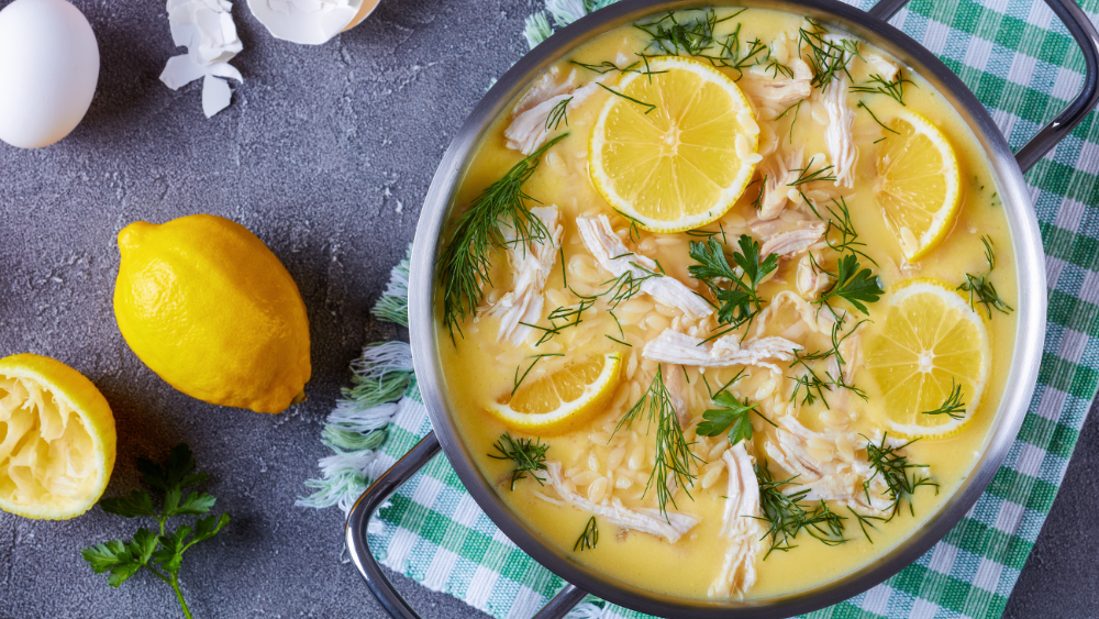 Greek Lemon Chicken Soup in a bowl with lemons on the side.