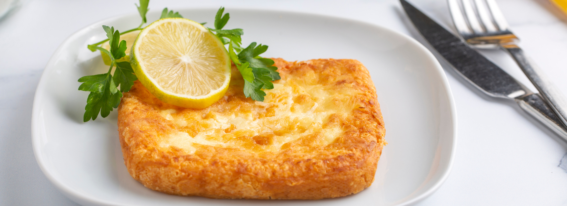 Fried Saganaki with a slice of lemon on a white plate